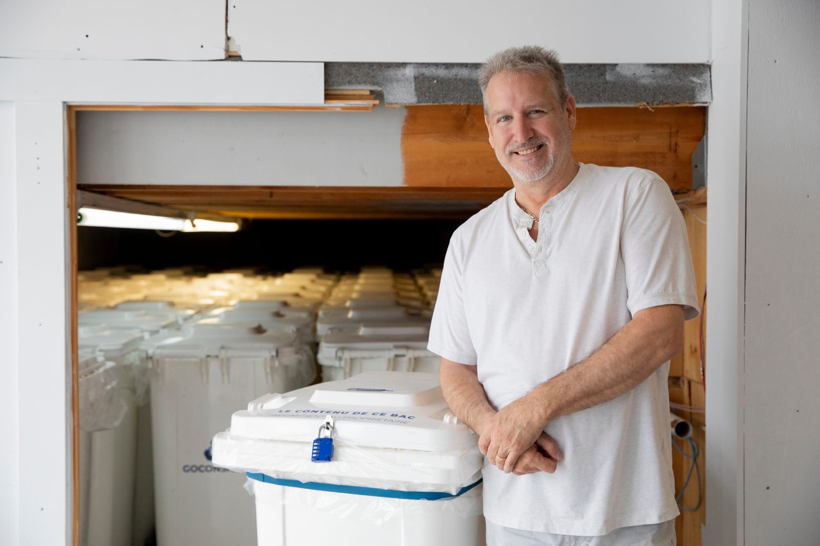 Un homme devant un camion rempli de bac blancs