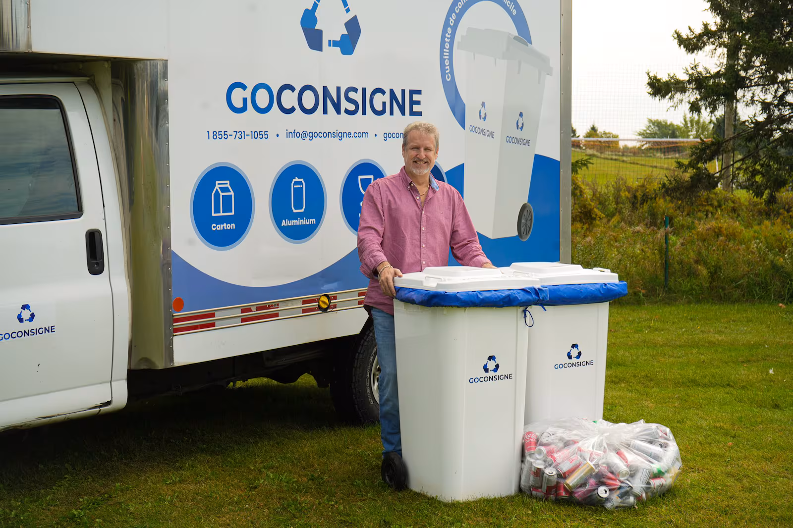 Un homme devant un camion et derrière un bac blanc